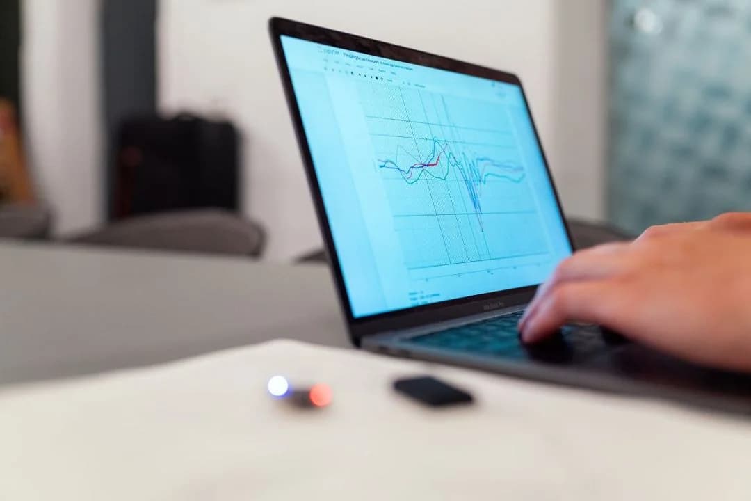 Researcher analyzing waveform data charts on a laptop, reflecting real-time ambulatory and momentary assessment